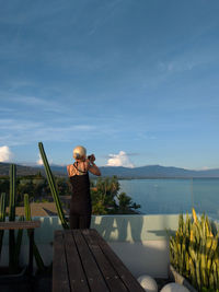 Woman at roof hotel in lovina beach, bali, indonesia with beautiful landscape as background.