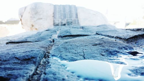 Close-up of frozen sea against sky during winter