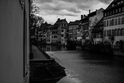 Canal amidst buildings in city against sky