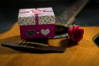 Close-up of rose and box on guitar