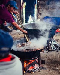 Midsection of man preparing food on barbecue grill