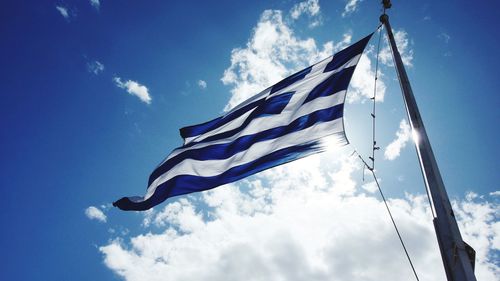 Low angle view of flag against blue sky