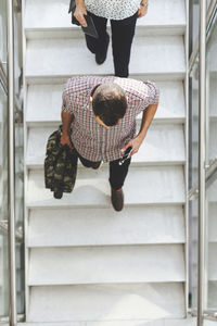 High angle view of businesspeople moving down steps in office