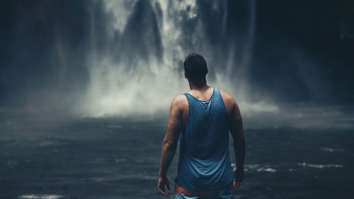 Rear view of man standing against sea