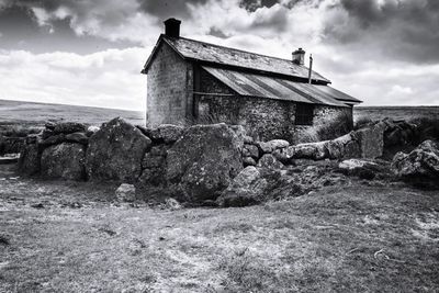 Abandoned house on field against sky