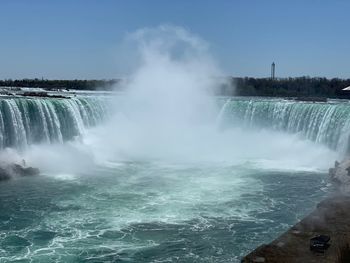 Scenic view of waterfall against sky