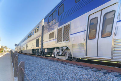 Train on railroad track against blue sky