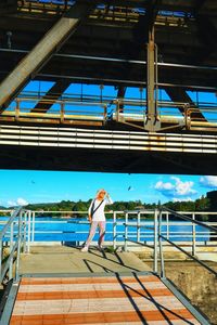 Rear view of woman standing on railing