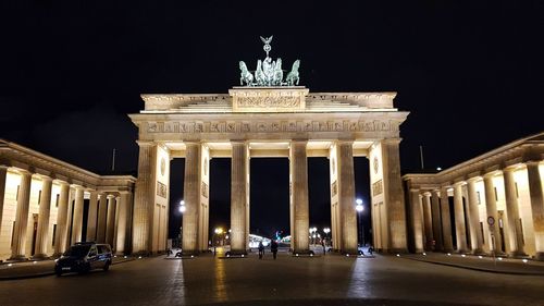 Statue in city at night