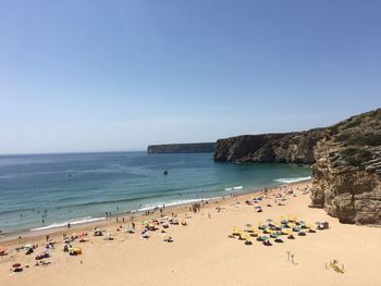 Scenic view of beach against clear blue sky