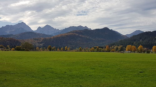 Scenic view of field and mountains against sky