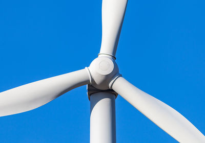 Cropped image of wind turbine against clear blue sky