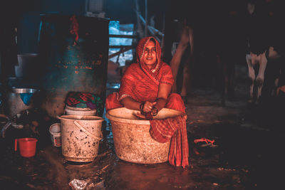 Full length portrait of a woman sitting at night