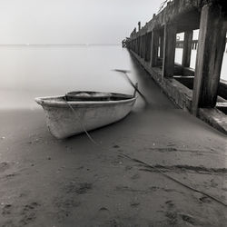 Abandoned fishing boat moored at beach