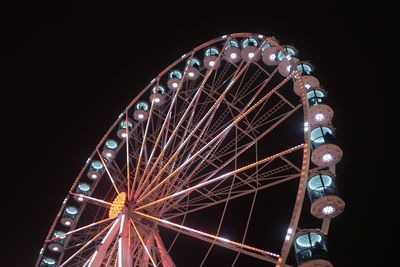 Low angle view of illuminated ferris wheel against sky at night