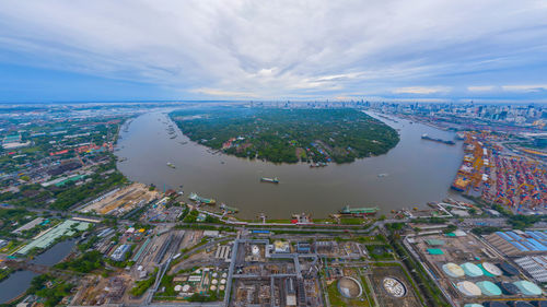 High angle view of city buildings against cloudy sky