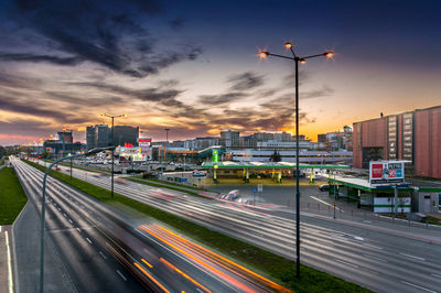 Light trails on road against sky at sunset