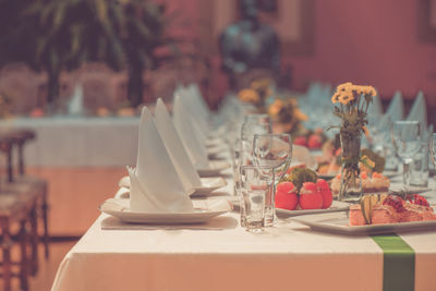 Long served table with dishes, retro toned