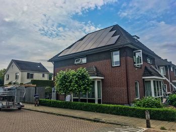 Houses by building against sky