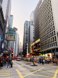 People crossing road against buildings in city