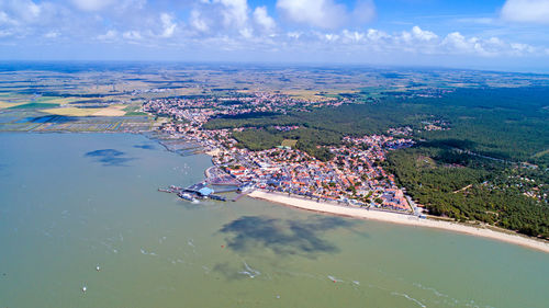 High angle view of cityscape by sea against sky