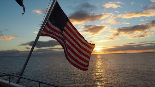Close-up of american flag against sky during sunset