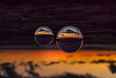 Close-up of lensballs against sky during sunset
