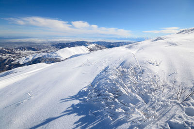 Snow covered landscape against sky