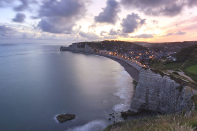 View of calm beach against cloudy sky