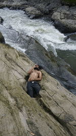 High angle view of man climbing on rock