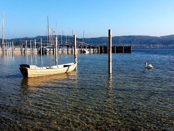 Boats moored in lake against sky