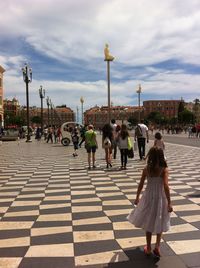 People walking on road against sky