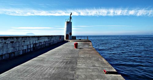 Scenic view of lighthouse by sea against sky