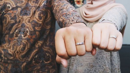 Midsection of couple holding hands