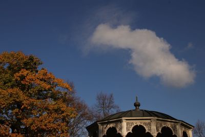 Low angle view of trees and building against sky