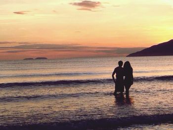 Silhouette of couple standing on beach