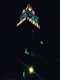 Low angle view of illuminated building against sky at night