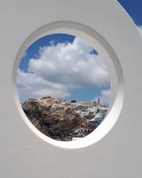 Panoramic view of buildings against sky seen through window