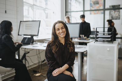 Portrait of smiling businesswoman sitting at corporate office