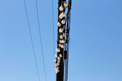 Low angle view of cables against clear blue sky