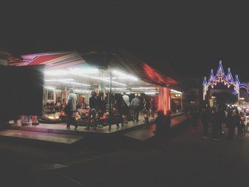 Group of people in amusement park at night