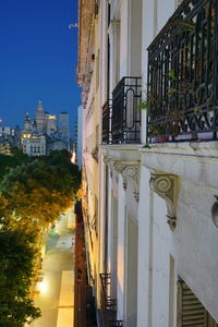 Buildings by street in city against clear sky