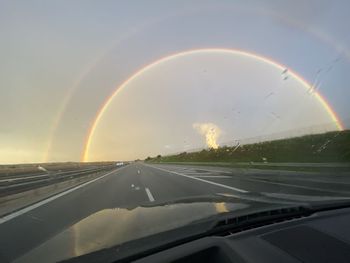 View of rainbow through car windshield