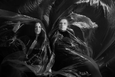 Portrait of women standing with plastic