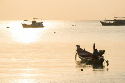 Fisherman in boat on sea against sky