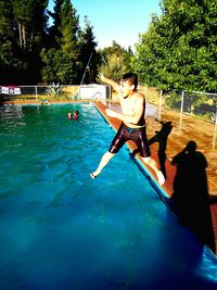 Boy in swimming pool against sky