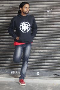 Portrait of young man standing against brick wall