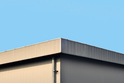 Low angle view of factory against clear blue sky