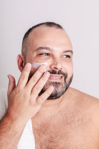 Close-up of young man wearing mask against white background