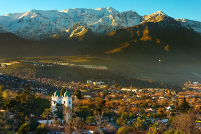 High angle view of townscape by snowcapped mountains